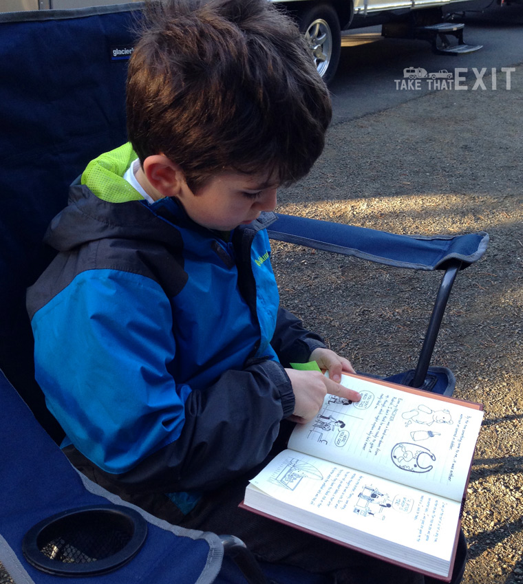 Reading by the campfire - great idea for camping with kids